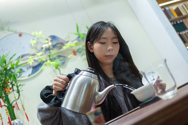 Asian young woman enjoys tea ceremony at home