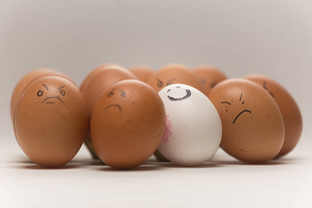 istock One smiling white egg versus 11 sad or angry brown eggs 2249928152