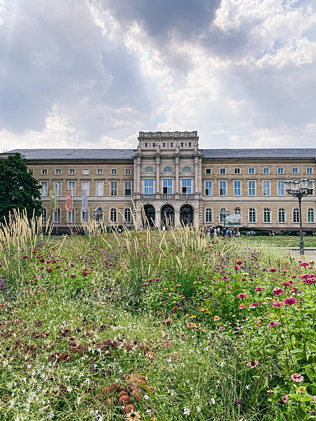 istock Historic building with elegant architecture surrounded by vibrant flowers and lush greenery, showcasing a beautiful garden landscape under a cloudy sky, perfect for nature and architecture enthusiasts 2249931081
