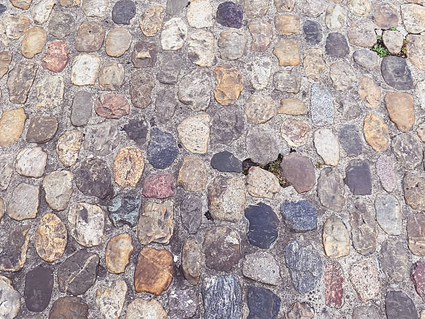 Textured cobblestone pathway featuring a variety of colors and shapes, creating a rustic and natural ambiance, ideal for outdoor settings and historical contexts