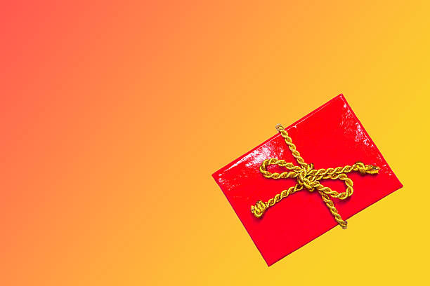 Christmas background - red gift box with golden cord over bright gradient background. Flat layout, top view composition border with copy space.