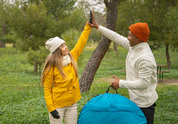 Two happy campers giving high five after setting up their tent in a campground