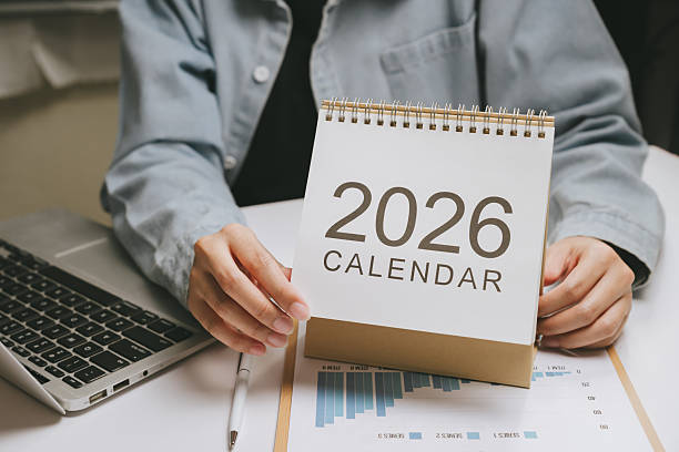 istock 2026 calendar desk calendar spiral bound planner organizer schedule office work concept with laptop and pen on table 2249938882