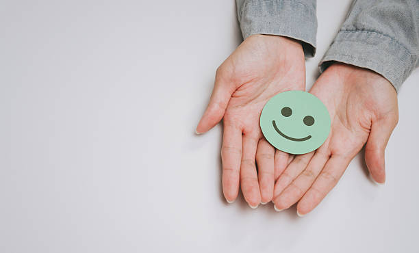 istock Smiling face icon on open hands with neutral background, symbolizing happiness, positivity, and emotional in simple and clean composition 2249940029