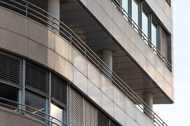 istock Modern commercial building facade with metal railings, vertical columns and shaded windows creating strong geometric lines and contemporary design 2249941093