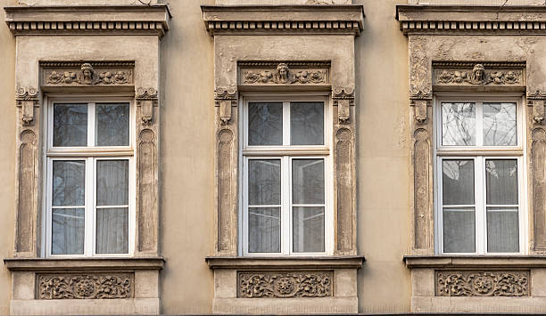 istock Fragment of a historic facade with three old windows and decorative architectural elements in a European urban style 2249941569