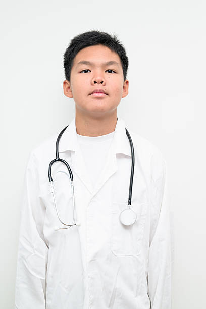 Portrait of a young Asian boy wearing a white lab coat and stethoscope. Suitable for healthcare, medical education, children profession dreams, and future doctor concepts.