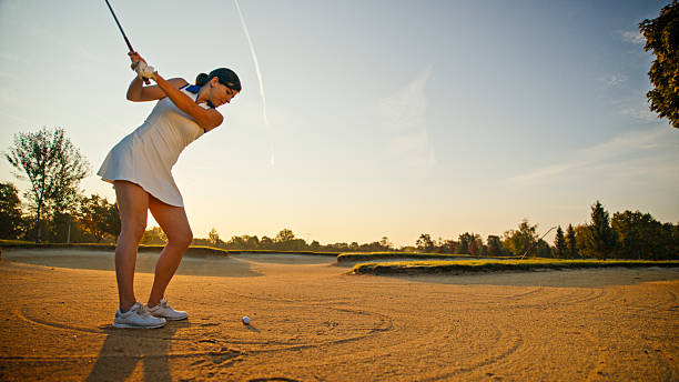 istock Woman Preparing Golf Swing in Sand Bunker at Sunset 2249947276
