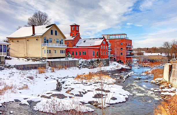 Old buildings lining the williams river running through the village of west stockbridge massachusetts on a sunny winter day.