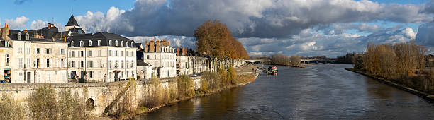 istock Panoramic view of the Loire river and Quai du Chatelet seen from the George V bridge in Orleans France. The riverbank is lined with historic buildings and autumn trees under a dramatic cloudy sky. 2249953607