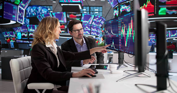 istock Man And Woman Trading Stocks On Computer At Stock Exchange 2249959059