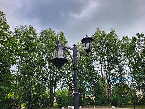 istock A broken lantern stands against a gloomy sky and a green park. 2249967777