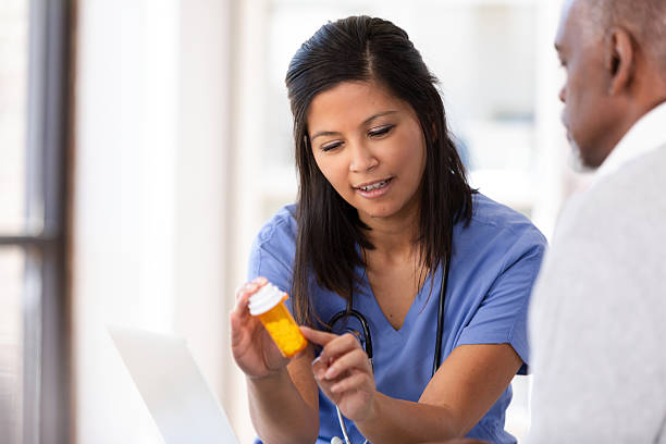 istock Doctor explaining medication to a patient while using a laptop in a medical setting. 2249971981