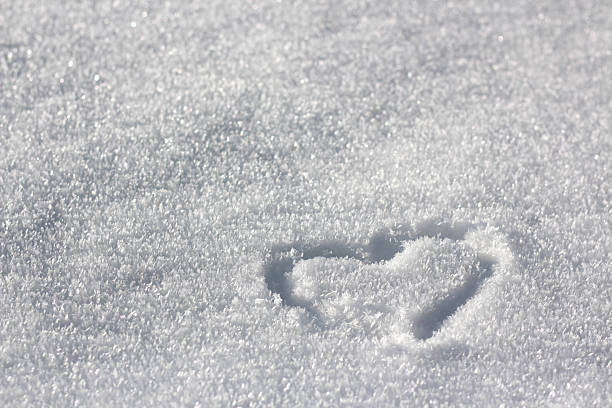 istock A small heart shape is traced into the sparkling, pristine surface of white snow, creating a serene and minimalist winter background symbolizing love. 2249972057