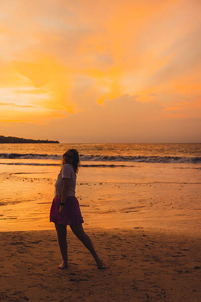 istock Woman Contemplating Dramatic Sunset Over Ocean on Bali Island 2249973055