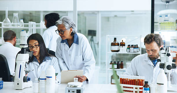 istock Coworking, science or people with microscope in lab, blood sample analysis or experiment for pathology. Medical research, study reaction or scientist team with report file, trial or test feedback 2249973096
