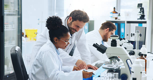 istock Pathology, science or team with results in lab, check virus sample or pointing for experiment evaluation. Medical, scientist or people with research report for disease, collaboration or vaccine trial 2249973191