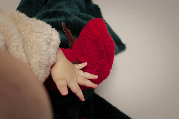 The gentle touch of a baby on soft red and green fabrics, expressing sensory exploration.