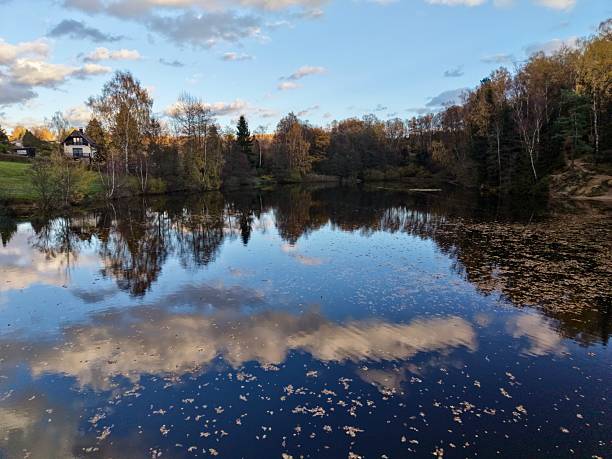 istock tranquil evening with colorful reflections, peaceful waters mirror sky and autumn foliage nearby 2249975012