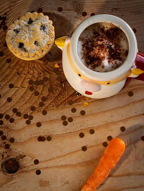 Santa Claus mug with steaming hot chocolate, marshmallows, and whipped cream on rustic wooden table with gold confetti