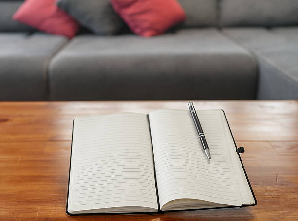 istock Close-up of an Open Planner on a Wood Desk 2249975506