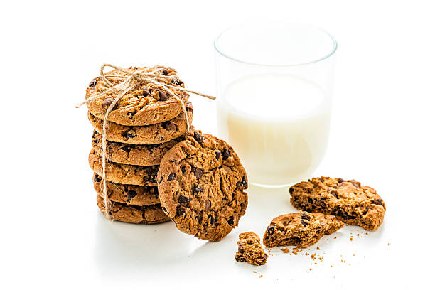 Stack of chocolate chip cookies tied with a string and milk glass isolated on white background. Crunchy and tasty sweet food or dessert