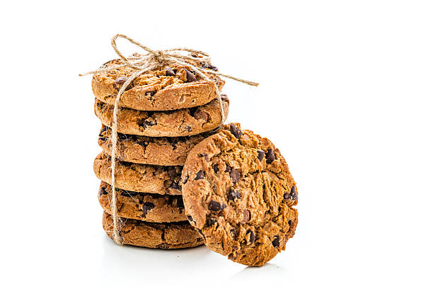 Stacked chocolate chip cookies in a clear plastic tray on a white background. Crunchy golden biscuits perfect for snack, packaging design, bakery display or dessert advertising visuals.