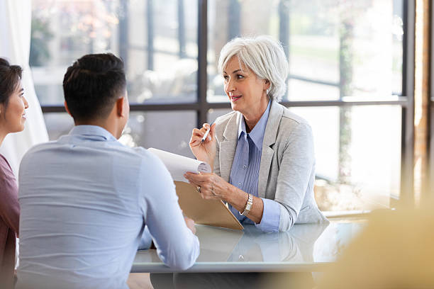 istock Professional discusses a plan with a couple in an office setting, offering guidance and support. 2249976374