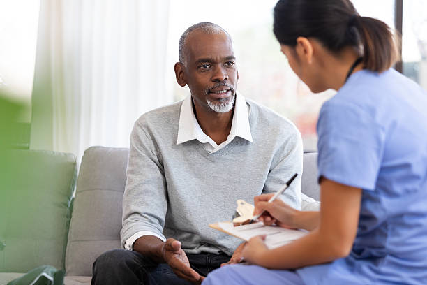 istock Older man discusses concerns with a medical professional while they take notes on a clipboard. 2249976954