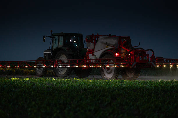 istock Tractor spraying vegetable field in sunset. 2249978249