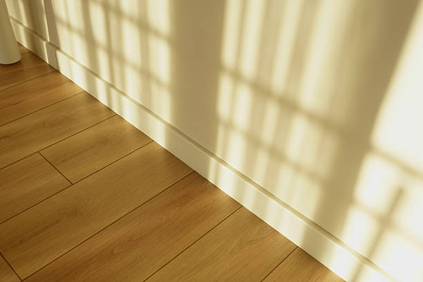 istock Shadows cast on wooden floor from window at morning light time 2249978309