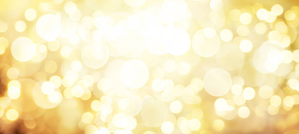 istock Golden bokeh background with sparkling, glowing circles. Bright and festive abstract texture for Christmas, New Year, party, and celebration concepts. Warm, diffused light effect. Horizontal banner. 2249979328
