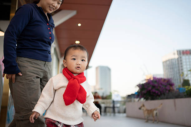 Joyful interaction between Asian baby and mother on the terrace