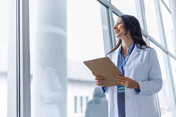 istock Female doctor smiling looking out office window 2249981368