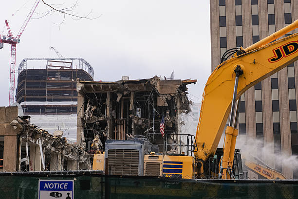 Excavator demolishing concrete structure in urban construction area.