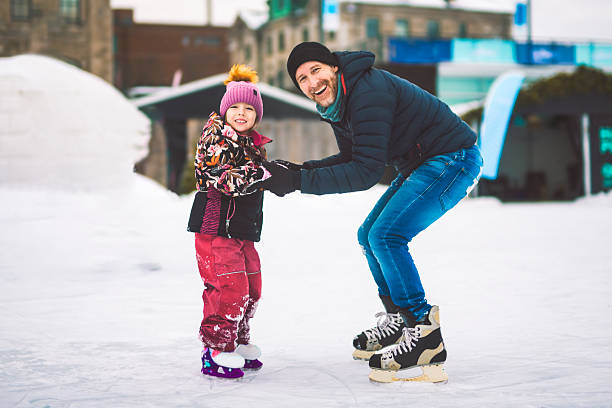 istock Happy father and daughter on winter day learning skating 2249987075