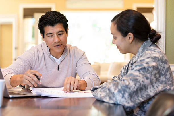 istock Man explains paperwork to woman in military uniform indoors, focusing on shared task. 2249987375