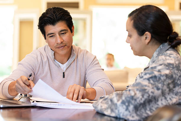 istock Soldier discusses important documents with a civilian professional indoors. 2249987378
