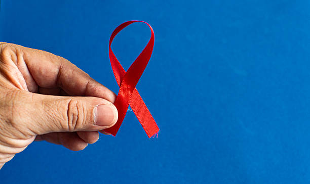 istock Hand holding red ribbon for World AIDS Day awareness 2249987916