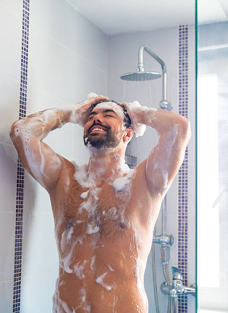 istock Young smiling man taking a morning shower 2249988159