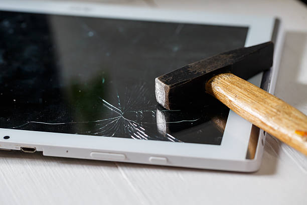 istock The hammer hits the broken touchscreen tablet, suggesting that it is about to replace it. Broken glass tablet repair 2249989324