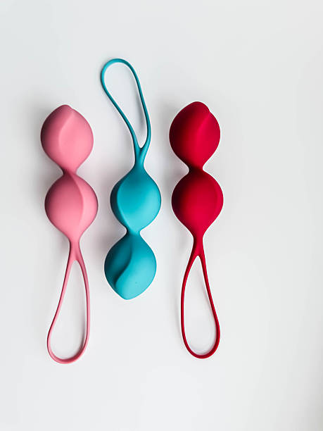 Three silicone kegel balls in pastel colors arranged vertically on white background, minimal product shot