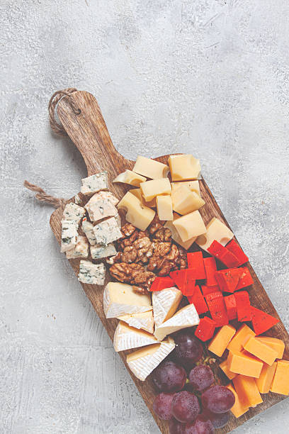 istock Assorted cheese on a wooden board, with grapes and walnuts, appetizer, no people. 2249994100