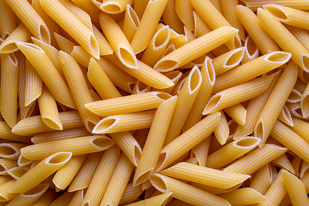 istock Raw Organic Dry Penne Pasta, top view. Overhead, flat lay, from above. 2249994473