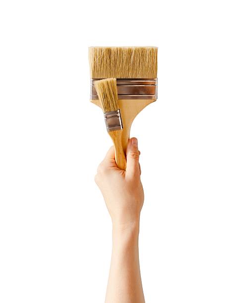 istock Isolated Hand Holding Paintbrushes Against Transparent Background 2249994525