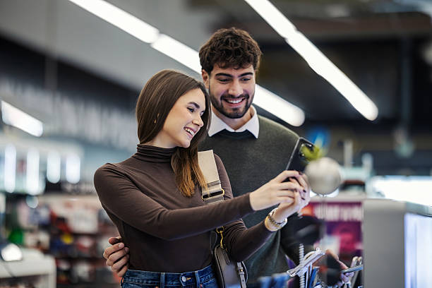 istock Happy couple shopping for new smartphone in electronics store 2249995230