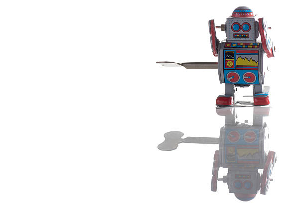 VINKOVCI, CROATIA - 23 MARCH 2020: Vintage toy robot illuminated by a reflector with a long shadow behind it.