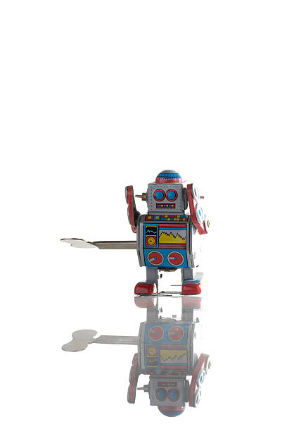 VINKOVCI, CROATIA - 23 MARCH 2020: Vintage toy robot illuminated by a reflector with a long shadow behind it.