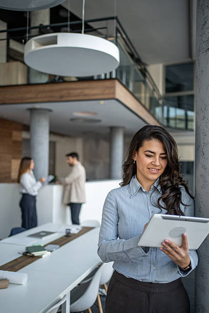 istock Businesswoman standing in office using digital tablet 2249999874