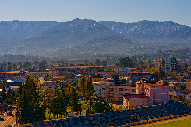 istock Sunny Town View with Misty SnowCapped Mountains Background 2250000833